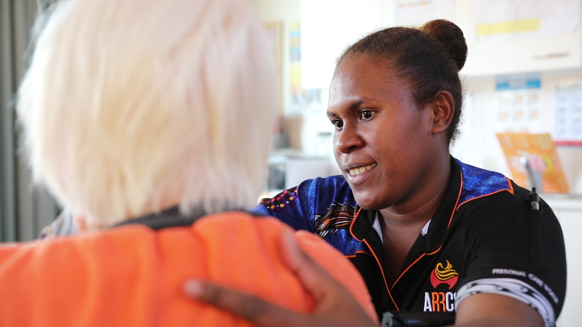 A Solomon islands aged care worker helps a resident