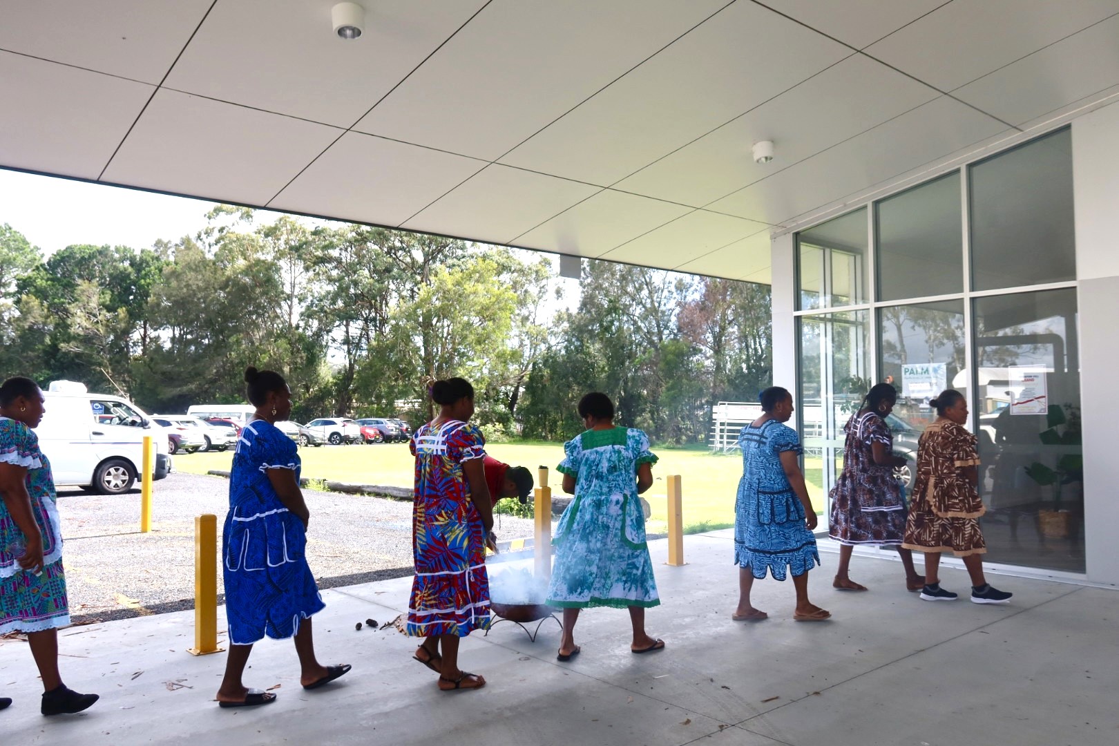 PALM scheme workers walking through smoke at welcome to country ceremony