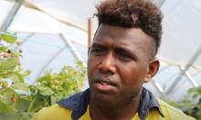 A Solomon Islands man in a yellow shirt standing under a tunnel.