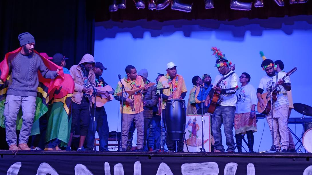 Men play instruments on a stage.