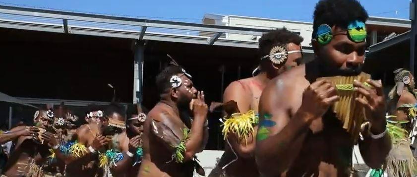 Solomon Islands men in traditional costumes playing panpipe